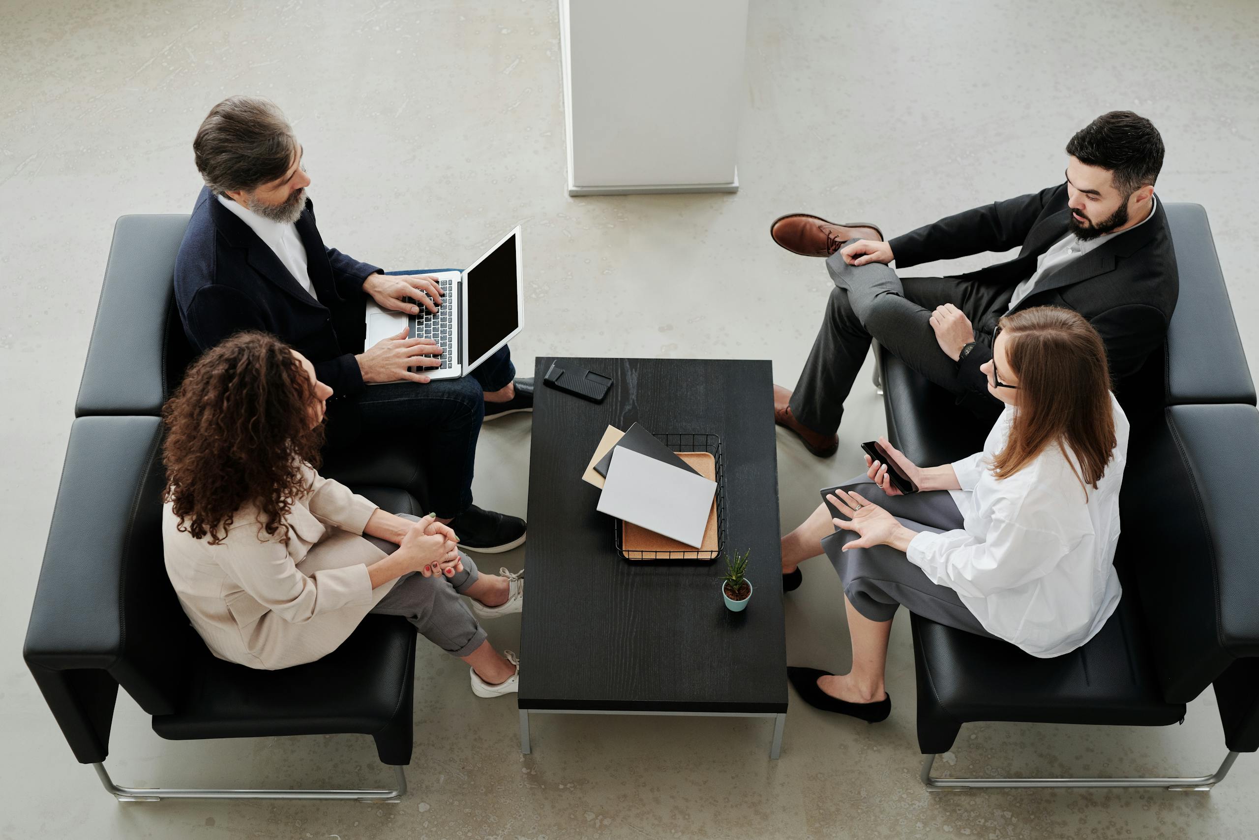 Professional team meeting in modern office setting with diverse colleagues discussing a project.